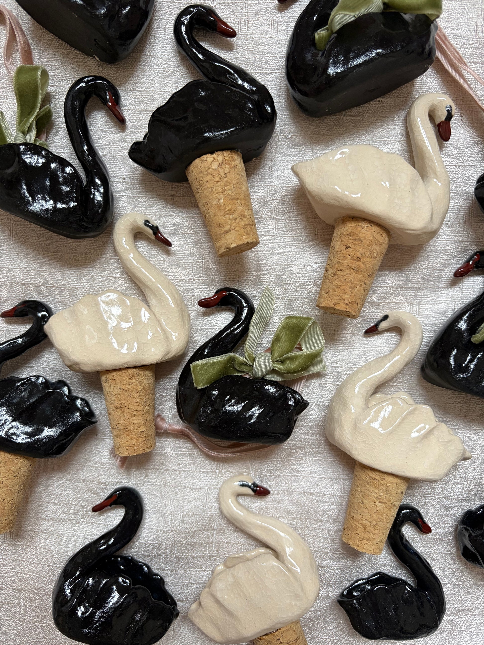 Hand sculpted ceramic swan bottle stoppers and ornamental hanging swan ornaments